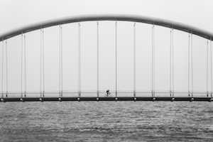 Men crossing a bridge in Canada with his Bridging Open Work Permit (BOWP)